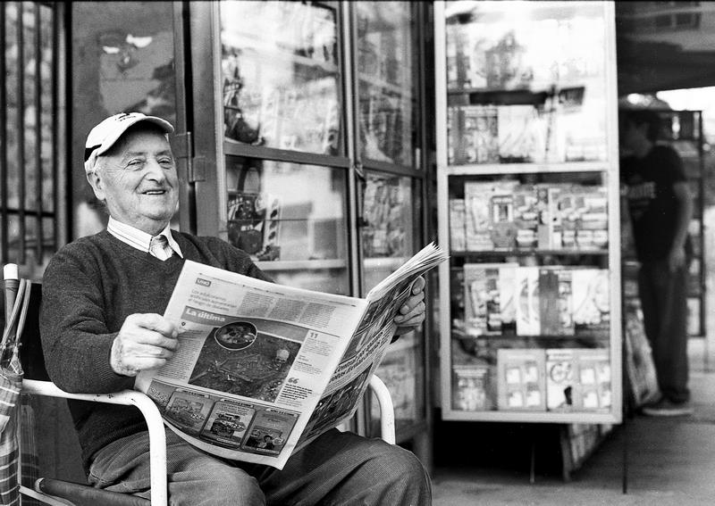Un vecino lee el diario en el quiosco
